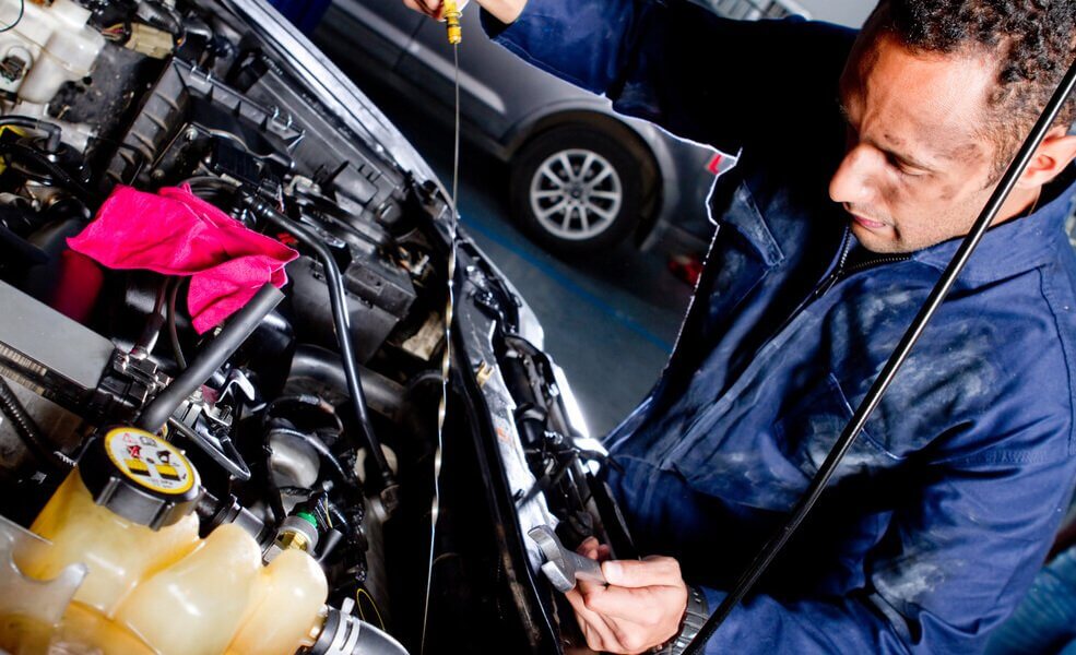 Mechanic checking oil levels of a car